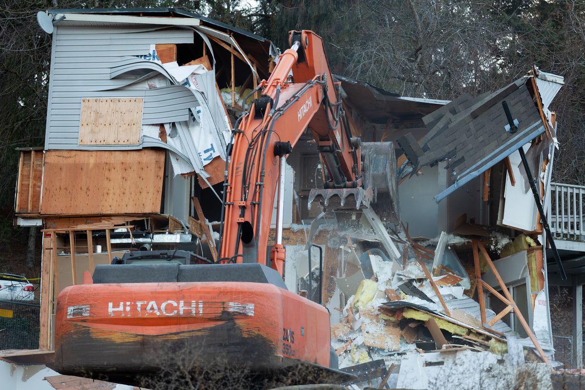 An excavator Thursday tears down the home where four University of Idaho students were killed last year in Moscow, Idaho.  (Geoff Crimmins/For The Spokesman-Review)