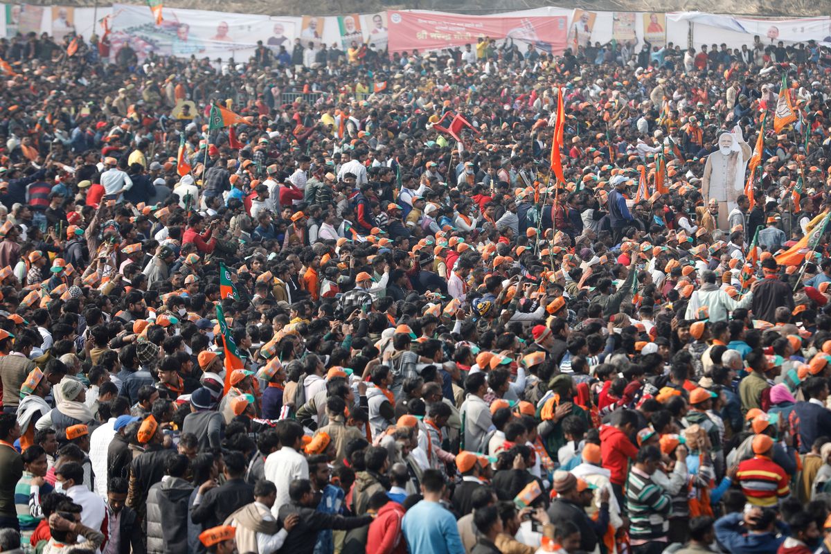 A crowd of supporters gather to listen to Indian Prime Minister Narendra Modi as he lays the foundation stone of Major Dhyan Chand Sports University in Meerut, Uttar Pradesh state on Jan. 2, 2022. Coronavirus cases fueled by the highly transmissible omicron variant have rocketed through India and the country is scrambling to ward off its impact by swiftly introducing a string of restrictions that the population thought were history. But India’s political leaders, including Modi, have largely flouted some of these guidelines and traversed cities in a massive campaign trail ahead of crucial state polls, addressing packed rallies of tens of thousands of people without masks.  (Rajesh Kumar Singh)