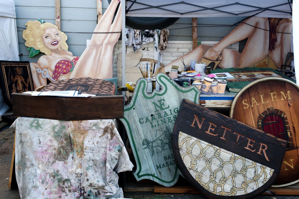 Michael Ruby’s signs are shown at MoMike Demolition in Spokane Valley. In the foreground are props for a 20th Century Fox television miniseries about 1600s-era Salem, Mass. In the back are pinup signs for MoMike Demolition building decor. (Tyler Tjomsland)