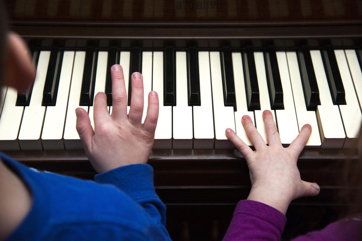 Avery Good, 5, and Elise Cereghino, 3, tap on the keys of a 1948 Everett piano that once belonged to Doug Clark