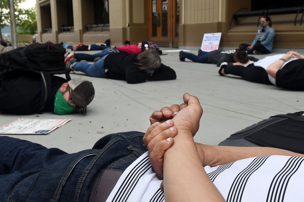 A protester holds his hands behind his back while laying on the pavement in front of Spokane City Hall on Friday, June 12, 2020, as they recite the words that were said by George Floyd during the last 8 minutes and 46 seconds of his life.  (Kathy Plonka/The Spokesman-Review)