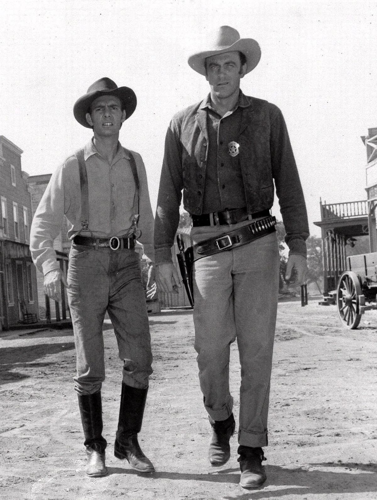 ** FILE ** This 1956 file photo shows actors Dennis Weaver, left, as the slow-witted deputy Chester and James Arness as Marshall Matt Dillon, are shown in a scene from CBS