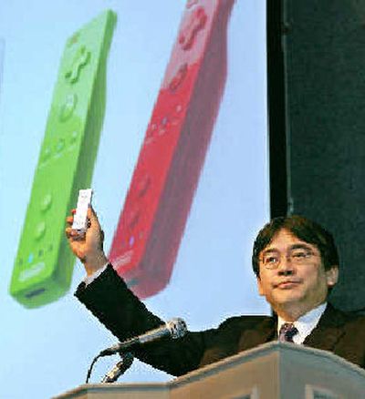 
Nintendo Co. Ltd. President Satoru Iwata displays a new smaller remote control device.  
 (Associated Press / The Spokesman-Review)