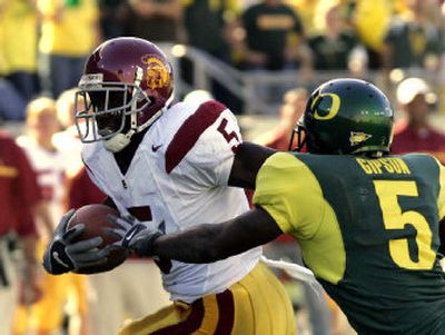 
USC running back Reggie Bush, left, evades Oregon defender Aaron Gipson during first-half action on Saturday in Eugene, Ore.
 (Associated Press / The Spokesman-Review)