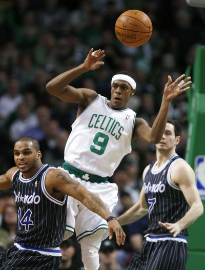 Rajon Rondo, who led the Celtics with 17 points, passes between the Magic’s Jameer Nelson, left, and J.J. Redick. (Associated Press)