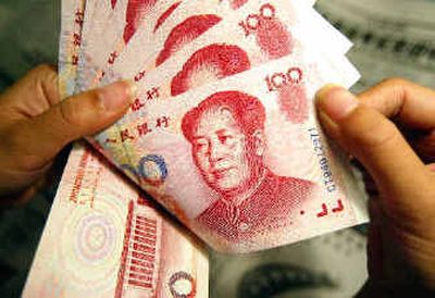 
A woman holds Chinese 100 yuan notes, featuring a portrait of late communist leader Mao Zedong. China has no immediate plans to let the value of its currency rise, despite renewed pressure at a weekend meeting of Group of Seven finance officials, the government said Monday.
 (Aassociated Press / The Spokesman-Review)