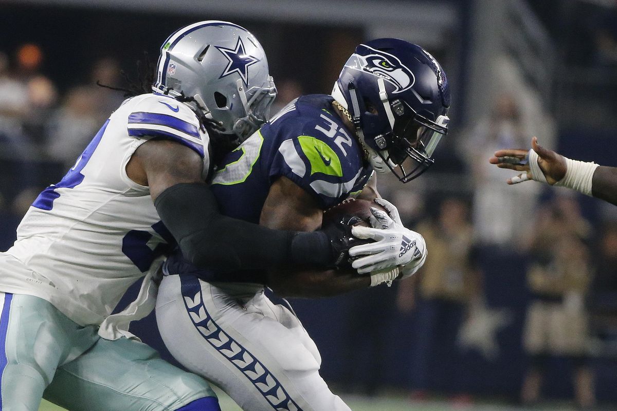 Seattle Seahawks running back Chris Carson  runs against the Dallas Cowboys during the first half of the NFC wild-card game in Arlington, Texas, on Saturday. (Michael Ainsworth / AP)