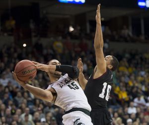 Michigan State guard Denzel Valentine (45) heads to the basket as Harvard guard Brandyn Curry (10) defends in the first half during the third-round game of the NCAA college basketball tournament in Spokane, Wash., Sat., March 22, 2014. (The Spokesman-Review)
