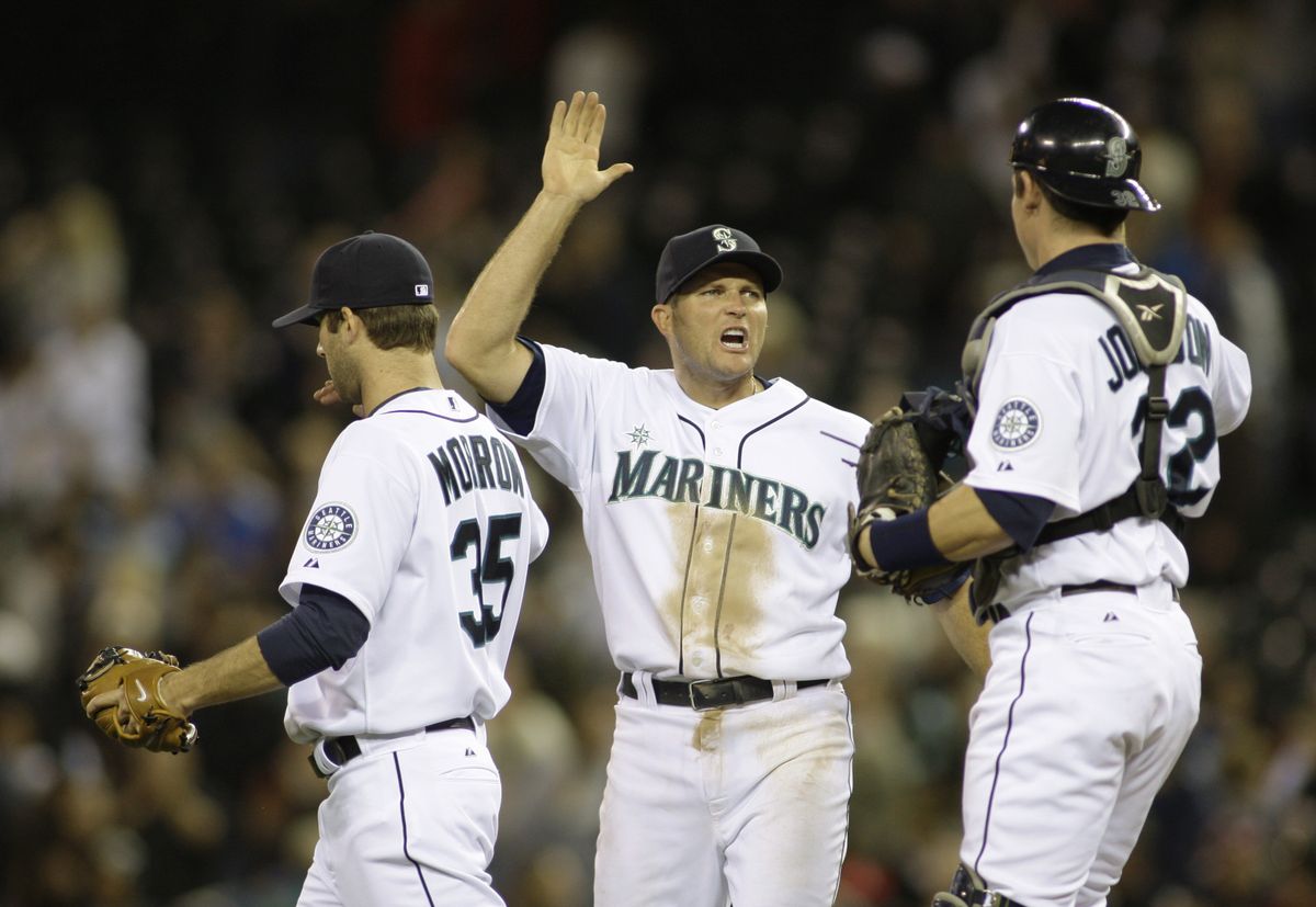 Mike Sweeney, center, celebrates the Mariners’ victory over the Rays with catcher Rob Johnson, right, and closer Brandon Morrow. (Associated Press / The Spokesman-Review)