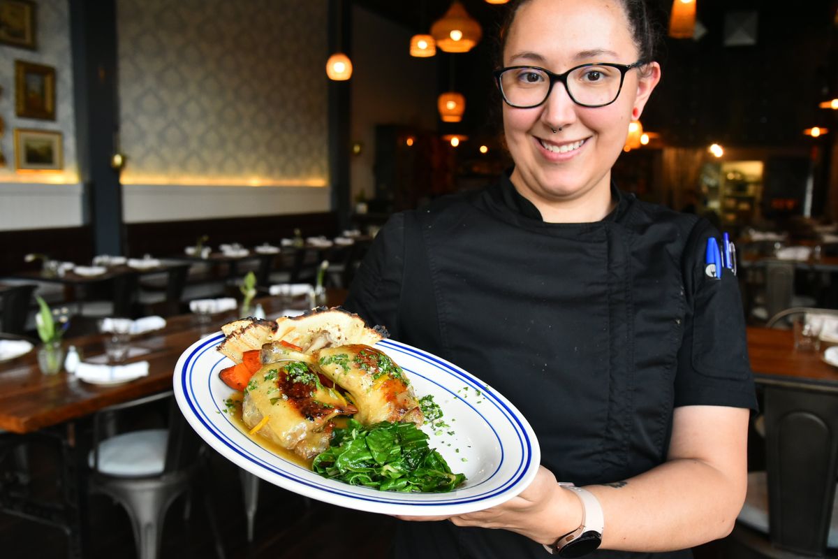 Executive Chef Kayleigh Wytcherley, who is opening Adam Hegsted’s Francaise restaurant in the Perry District in Spokane, holds her version of canard l’orange, a pair of duck legs, served with wilted greens, sweet potato and crepes under an orange sauce Saturday at the new restaurant which took the place of Casper Fry.  (Jesse Tinsley/The Spokesman-Review)