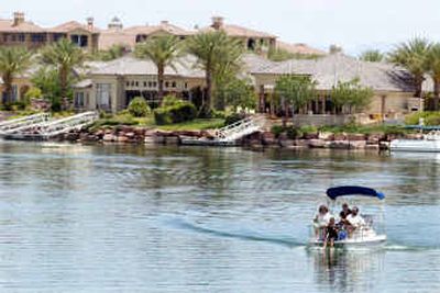 
A family takes a boat ride on Lake Las Vegas in Henderson, Nev. The man-made lake is surrounded by an upscale residential development 17 miles from Las Vegas Boulevard. The resort has golf courses, Ritz-Carlton and Hyatt Regency hotels, and the Mediterranean-themed MonteLago Village with condominiums, a casino, boutiques and restaurants.
 (Associated Press / The Spokesman-Review)
