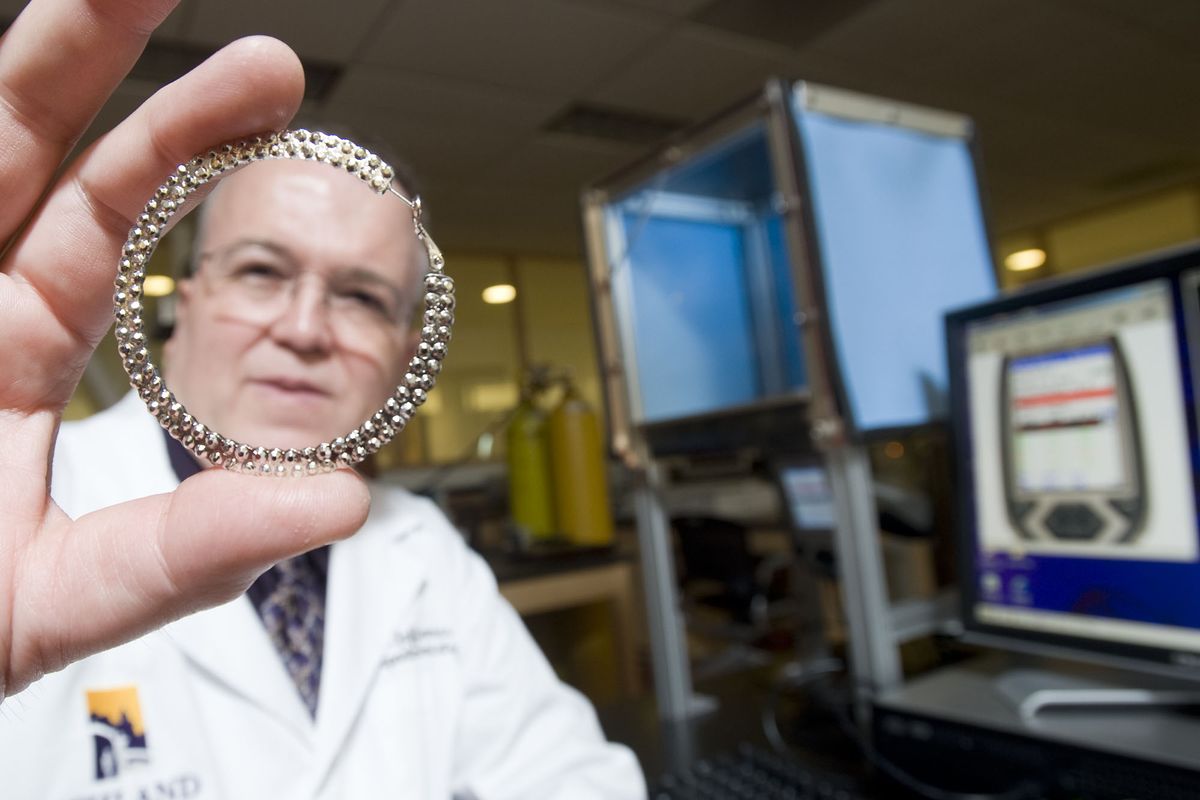 Ashland University chemistry professor Jeff Weidenhamer displays a hoop earring in his laboratory at the university in Ashland, Ohio, earlier this month. The earring, and a variety of other small bracelet charms and pendants that Weidenhamer has tested, were shown to contain the metal cadmium. Associated Press photos (Associated Press photos)