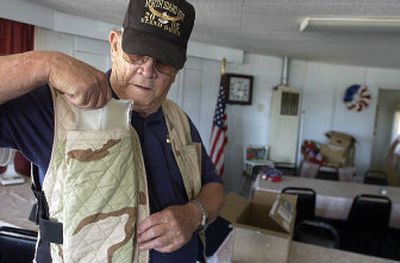 
John Dunlap, a Vietnam veteran, tries on a cooling vest, which has pockets for packets of chilled coolant, at American Legion Post 143 in Post Falls on Tuesday. 
 (Jesse Tinsley / The Spokesman-Review)