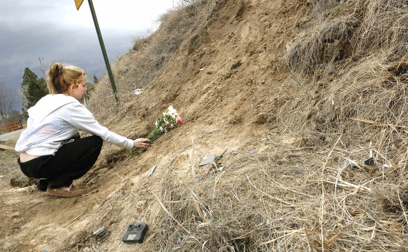 Lindsey Grubb, 18, a 2009 graduate from Helena High School, places flowers near the site of the early Sunday single vehicle accident that took the life of her friend, Andre D. Hartwig, and four other Helena area teens on Keir Lane near Helena, Mont. on Monday, March 20, 2010. (Eliza Wiley / The Independent Record)