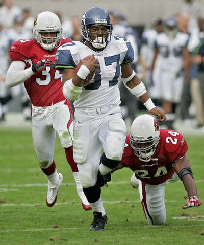 
Seahawks running back Shaun Alexander sprints past Cardinals defenders Robert Griffith, left, and Adrian Wilson on his way to an 88-yard touchdown on Sunday.
 (Associated Press / The Spokesman-Review)