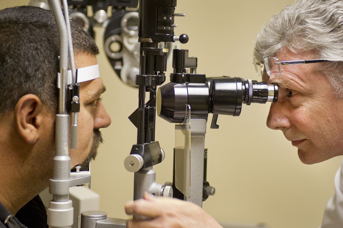 Dr. Rick Kellogg, right, examines Wayne Jones’ eyes Thursday at the Union Gospel Mission.