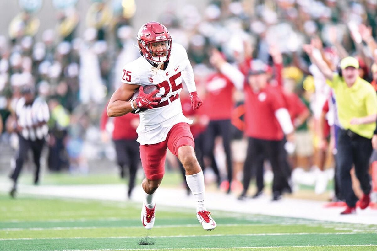 Washington State’s Jaden Hicks smiles as he runs to the end zone with an interception against Colorado State last season.  (Tyler Tjomsland/The Spokesman-Review)