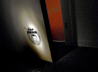 
A Coeur d'Alene fire inspector shines a light on a Tot Finder sticker at the fire station in Coeur d'Alene. The Coeur d'Alene Fire Department is giving away 1,000 of the  stickers. 
 (Kathy Plonka / The Spokesman-Review)