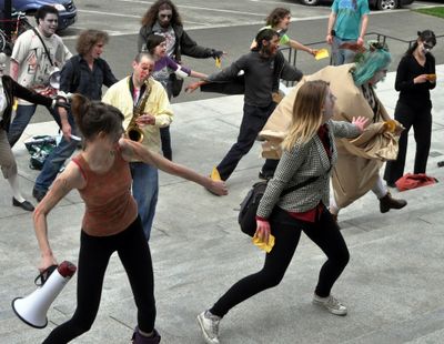 Demonstrators dressed as zombies dance “The Monster Slash” on Friday outside the state Capitol in Olympia.
