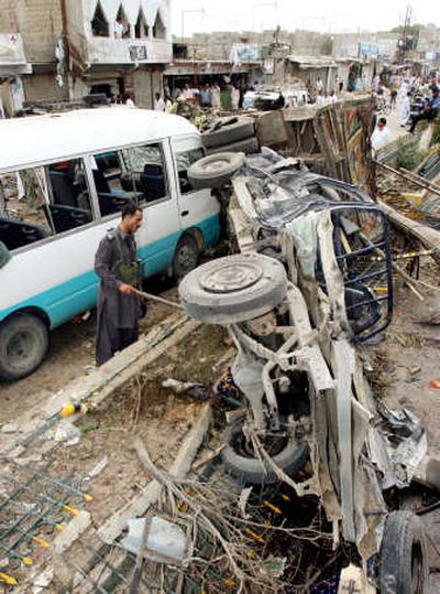 
A Pakistani security official examines wreckage of a vehicle after an  explosion in Hub near Karachi, Pakistan, Thursday.Associated Press
 (Associated Press / The Spokesman-Review)