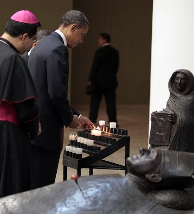 President Barack Obama lights a prayer candle at Archbishop Oscar Romero’s tomb during a tour with Monsignor Jose Escobar in San Salvador, El Salvador, Tuesday. (Associated Press)
