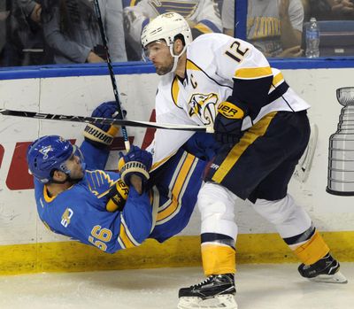In this April 2, 2017, file photo, St. Louis Blues’ Magnus Paajarvi (56), of Sweden, is checked by Nashville Predators’ Mike Fisher (12) during the third period of an NHL hockey game, in St. Louis. Mike Fisher has announced his retirement, a move that means the defending Stanley Cup finalists must select a new captain. Fisher, 37, said in a letter to Predators fans that “this is the hardest decision that I’ve ever had to make, but I know I’ve made the right one.” (Bill Boyce / AP)