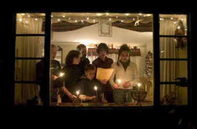 On the first night of the Jewish holiday of Hanukkah, members of the Amstadter family light their menorah candles as they recite the blessings in their South Hill home Tuesday evening.
(Colin Mulvany / The Spokesman-Review)