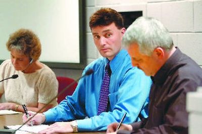 
Post Falls city Administrator Eric Keck, center, listens to architect Cory Trapp talk about the bids to build a new Post Falls City Hall  at the recent opening of bids. 
 (Jesse Tinsley / The Spokesman-Review)