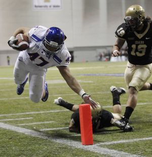 Boise State's Dan Paul (47) tries to stay in the field of play as he runs the ball near the goal line, but fails to score as Idaho's Aaron Grymes, center, and Homer Maugain, right, defend, the first half of an NCAA college football game, Friday, Nov. 12, 2010, in Moscow, Idaho. (Ted Warren / Associated Press)