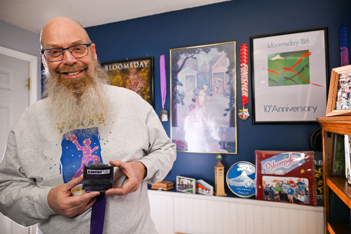 Jim Grier stands in his basement in Mead on Jan. 21, where he displays posters, photos, medals and other souvenirs from the first 49 years of Bloomsday road races he has completed and plans to do his 50th this year. He has also participated in triathlons, long bicycle rides and other endurance events.  (Jesse Tinsley/THE SPOKESMAN-REVIEW)