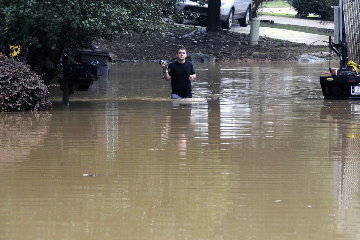 Michael Halbert wades through his flooded neighborhood Thursday in Pelham, Ala.  (Jay Reeves)