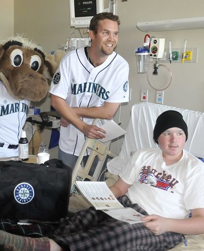 Mariners pitcher Tom Wilhelmsen, center top, poses for photos with patient Jethro Gross, 15, and the Mariner Moose Wednesday at Providence Sacred Heart Children’s Hospital (Jesse Tinsley)