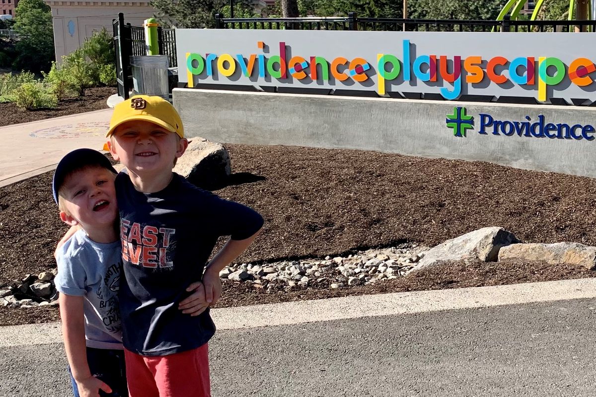 Brothers Colin and Shaun Hyams pose in front of the new Providence Playscape sign. (Courtesy Providence Health Care)