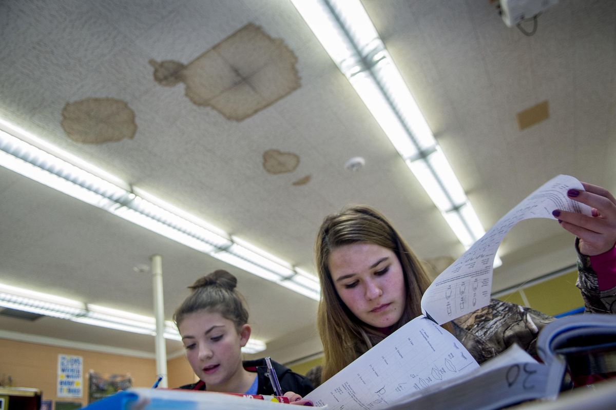 Water-stained ceiling tiles hang above Rylie Milholland, left, and Jezzy Hall as they study their notes during science class at Kellogg Middle School in Kellogg, Idaho, on Thursday, Nov. 10, 2016. Northwest senators are pushing for more federal money for rural schools before Congress recesses for the year. (Kathy Plonka / The Spokesman-Review)