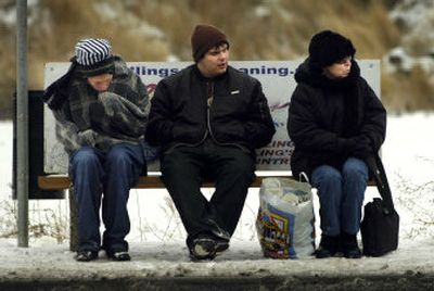 
North Central High School students Zeben Helton, left, and Nathan Berg, center, brace against the cold while they and Spokane resident Judy Willard  wait for a bus on South Regal in Spokane on Friday afternoon. 
 (Holly Pickett / The Spokesman-Review)