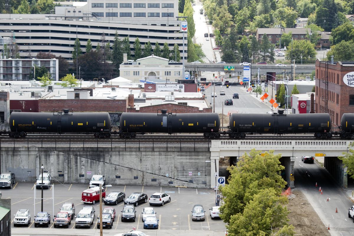 A westbound train carrying crude oil toward the coast passes through downtown Spokane in July. (Jesse Tinsley / The Spokesman-Review)