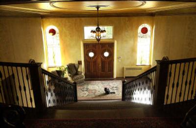 
A grand staircase with dark hardwoods is accented by warm colors and bold artwork in the foyer of the Schmautz home.  
 (photos by Brian PLonka/The spokesman-review / The Spokesman-Review)