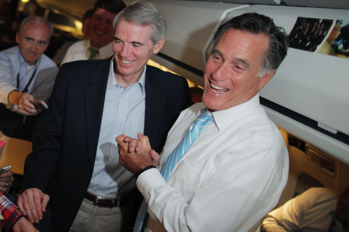 Republican presidential candidate and former Massachusetts Gov. Mitt Romney and Sen. Rob Portman, R-Ohio, talk to reporters on board the campaign charter plane as it flies to Bedford, Mass., Friday, Sept. 14, 2012. (Charles Dharapak / Associated Press)