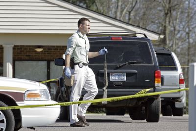 An investigator carries a weapon at the scene where a gunman opened fire at Pinelake Health and Rehab in Carthage, N.C., on Sunday morning.  The suspect was apprehended.  Associated Press photos (Associated Press photos / The Spokesman-Review)