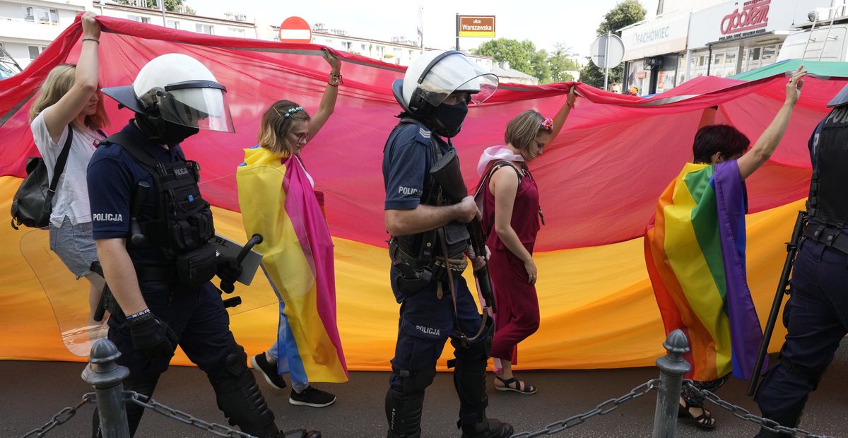 Participants in colorful 3rd Equality Parade march with rainbow flags under heavy police presence in support of LGBT rights at the foot of Poland