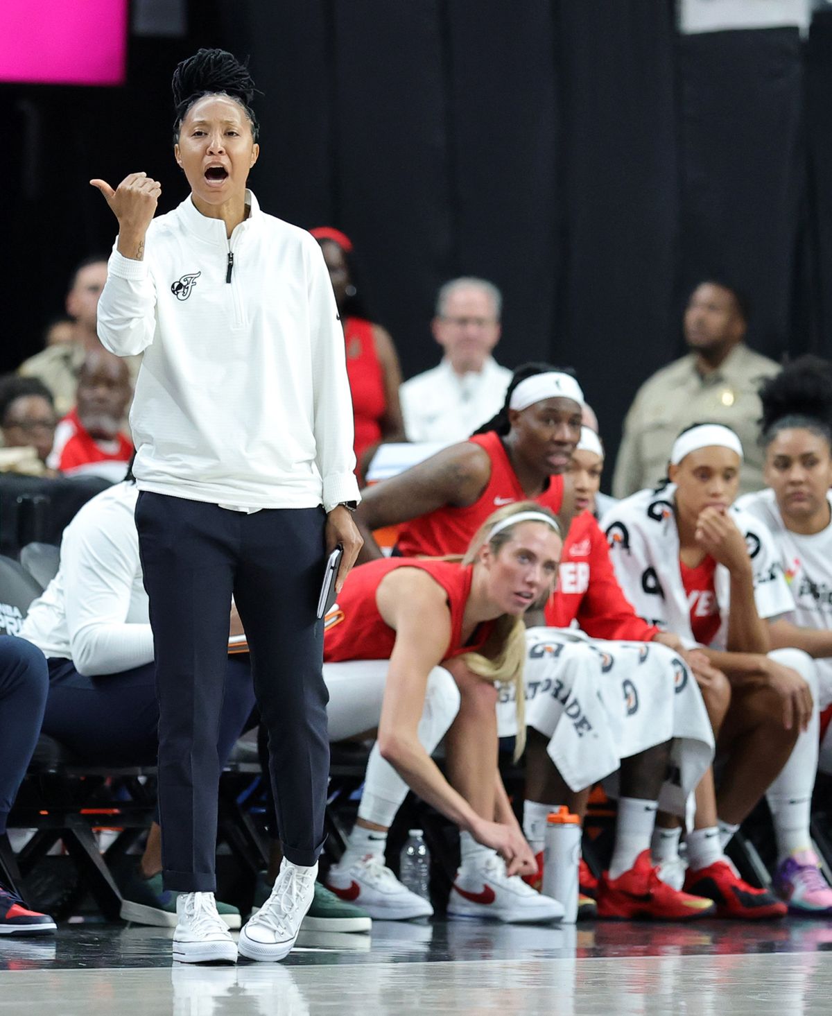 Indiana Fever assistant coach Briann January yells to players while Lexie Hull ties her shoe during a game against the Las Vegas Aces on June 22 in Las Vegas. (Getty Images)