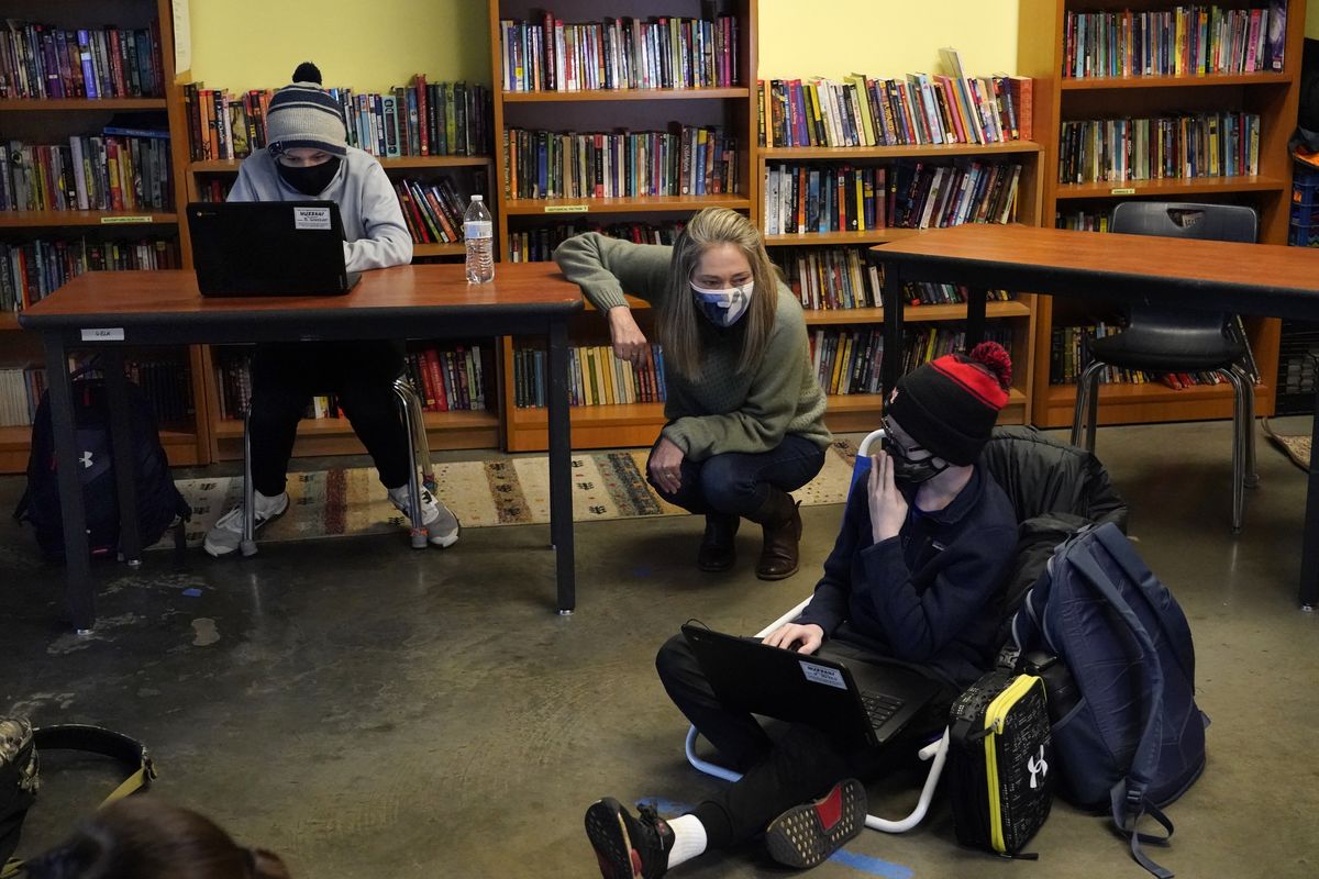Susannah Remillard, middle, speaks to one of her sixth-grade students at Cape Cod Lighthouse Charter School, Thursday in East Harwich, Mass. (Elise Amendola)