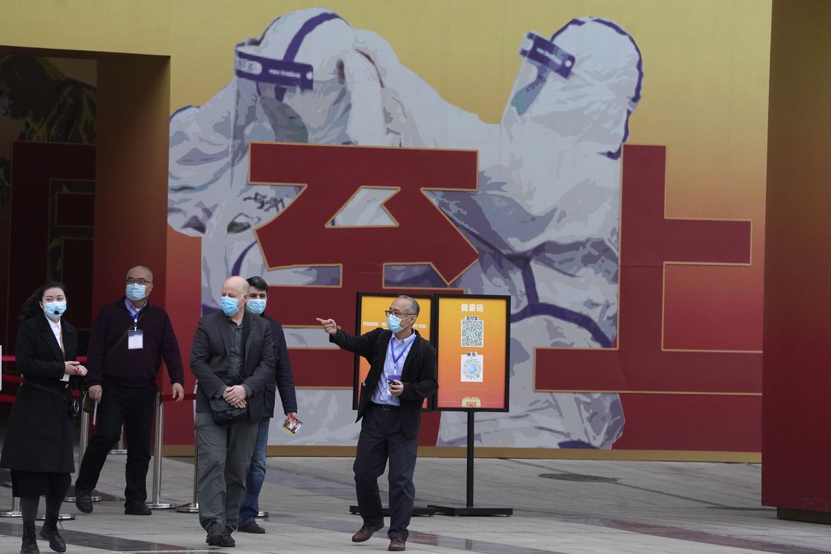 In this Jan. 30, 2021, file photo, members of the World Health Organization team including Ken Maeda, center, Peter Daszak, third from left and Vladmir Dedkov, fourth from left, leave after attending an exhibition about the fight against the coronavirus in Wuhan in central China