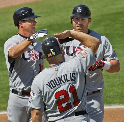 Team USA’s Chipper Jones, left, and Kevin Youkilis  greet teammate Adam Dunn after Dunn hit a fifth-inning three-run home run. (Associated Press / The Spokesman-Review)