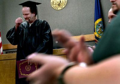 
At the Kootenai County Courthouse, Erick Nelson removes his glasses to wipe the tears from his eyes, as he graduates on Thursday from the Mental Health Drug Court program. 