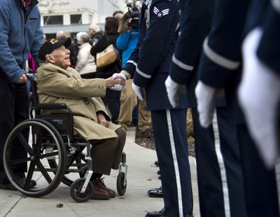 Pearl Harbor Survivor George “Bud” Garvin shakes the hands of Fairchild Air Force Honor Guard members Dec. 7 after a ceremony at the Spokane Veterans Memorial Arena to commemorate the 73rd anniversary of the attack that began America’s involvement into World War II. (FILE)