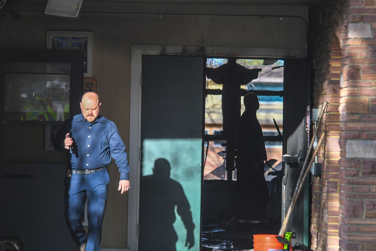 Investigators leave the scene of a fire at St. Charles Catholic School in this photo from March 18, 2021. A suspect, Rio Antonio Mirabal, was indicted on a federal charge Wednesday in connection with the fire.  (Dan Pelle/THE SPOKESMAN-REVIEW)