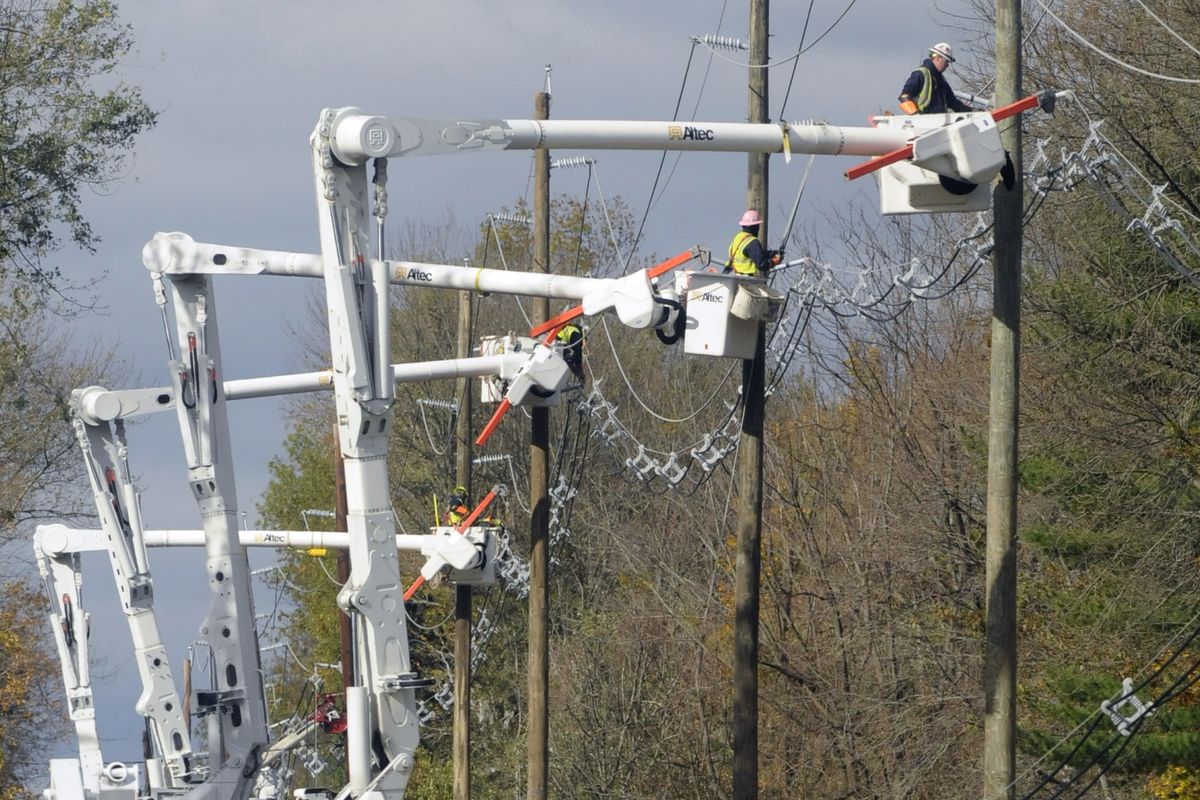 Visiting utility crews from the St. Louis-based Ameren Corp. restring power lines after replacing numerous downed and broken poles along Bull Run Road in Hopewell Township, N.J., on Saturday. (Associated Press)