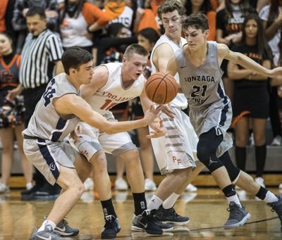 Gonzaga Prep’s Carter Sonneborn, left,  battles  Post Falls for a loose ball on  Dec. 7, 2017, in Post Falls. (Dan Pelle / The Spokesman-Review)