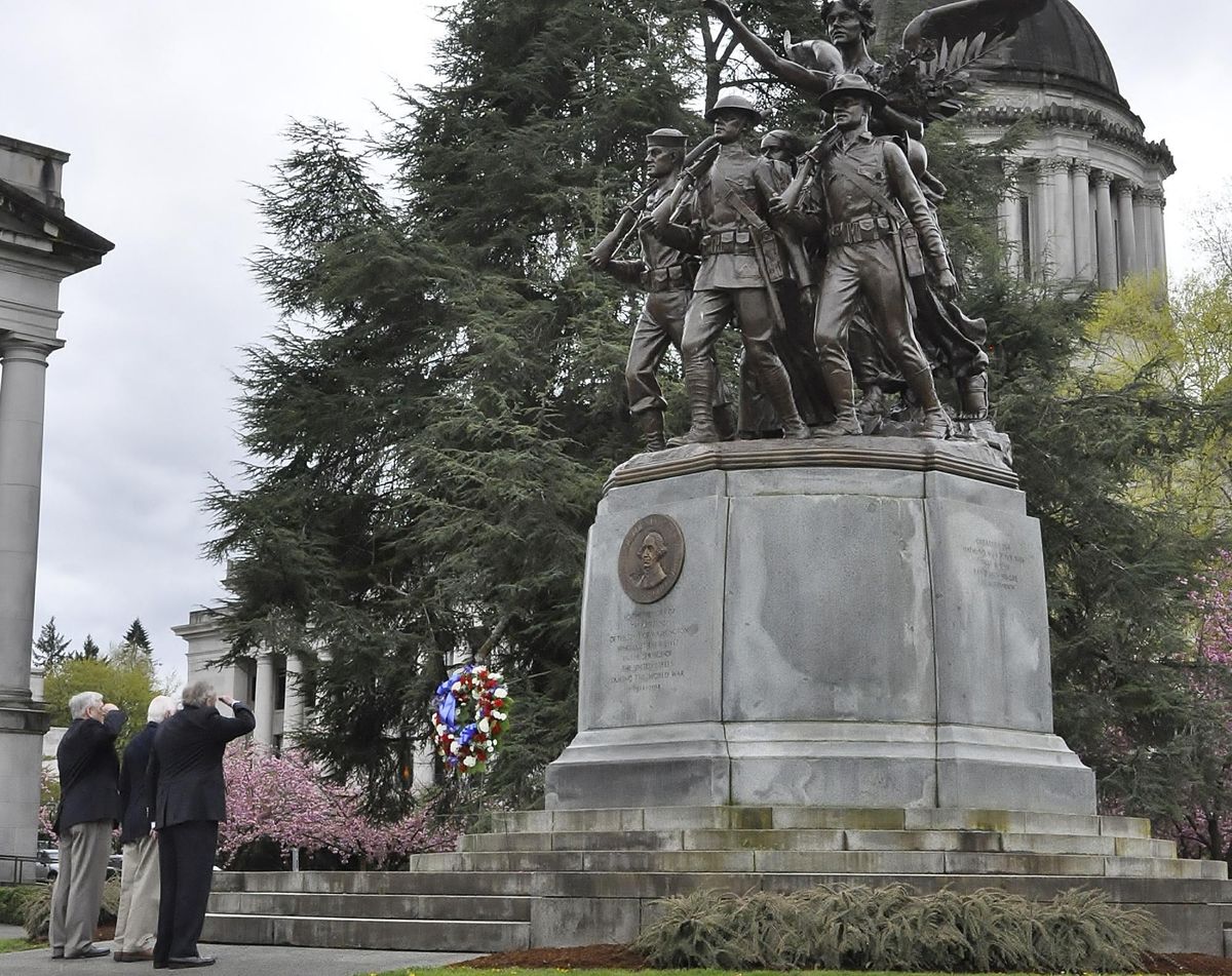 Keith Warren, John McConnel and Jack Jory, (from left) all former commanders of the Military Order of the World Wars, salute after placing a wreath Tuesday at the base of the World War I memorial on the Capitol Campus in Olympia. (Jim Camden / The Spokesman-Review)
